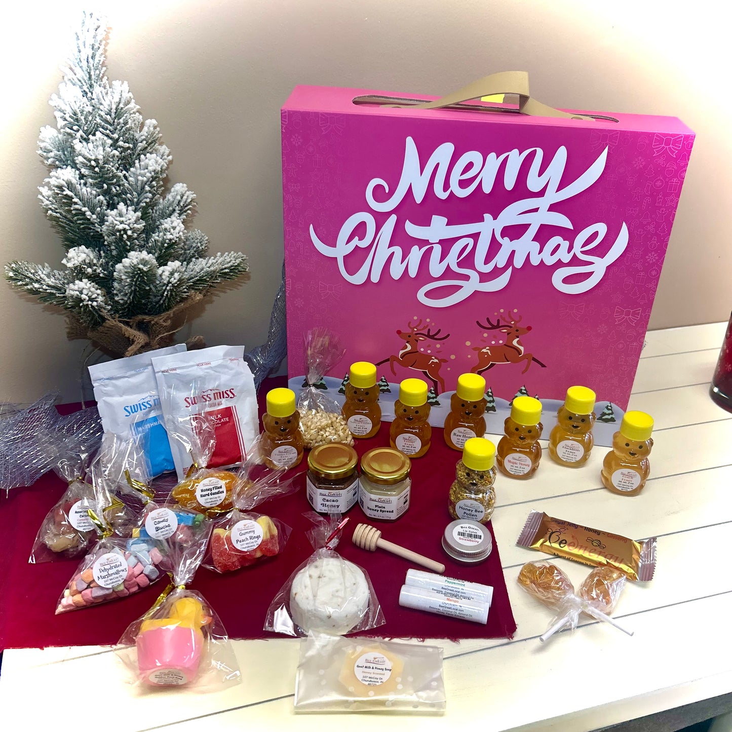 Assorted food items including honey, cookies, and a pink 'Merry Christmas' advent calendar on a table.